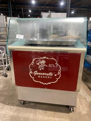 Commercial stainless steel 10-pan gelato case with sliding door access, on casters. Gencarelli's Bakery branding.