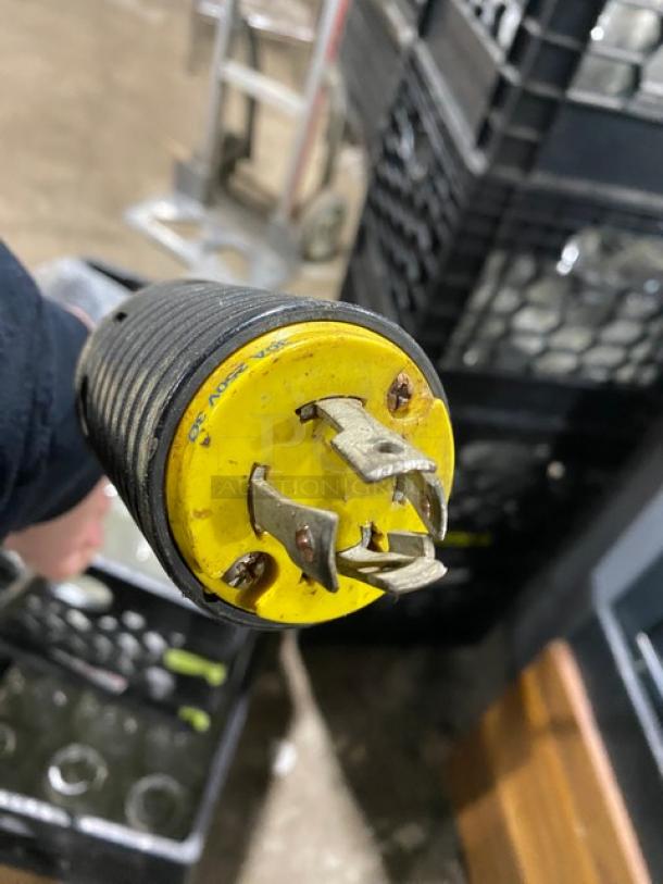 Yellow and black electrical plug with prongs and visible wear marks. No visible branding or model details.