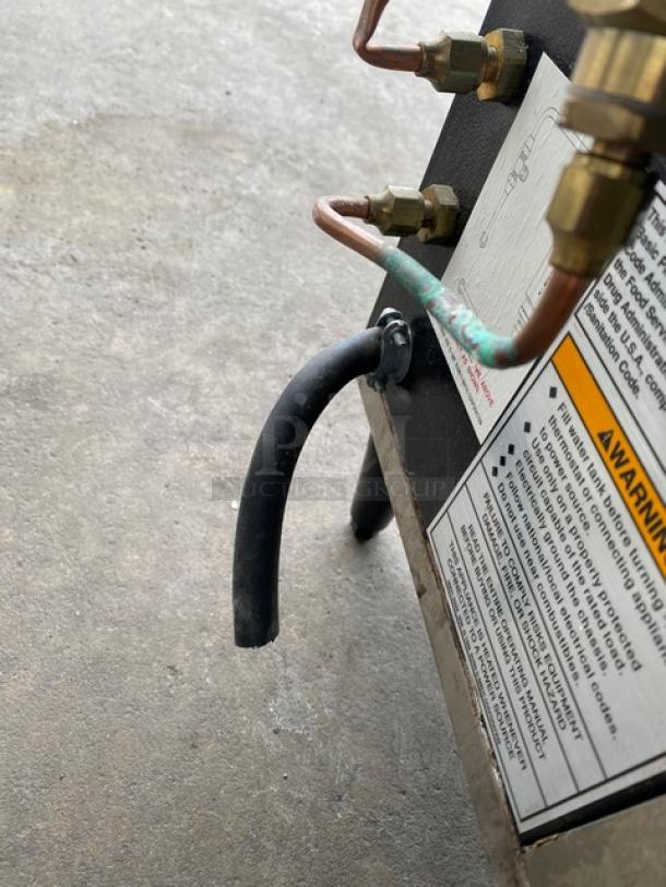 Bunn CWTF35 commercial coffee brewer, stainless steel, 4 warmers, hot water dispenser, brew basket, 120/240V, on legs.