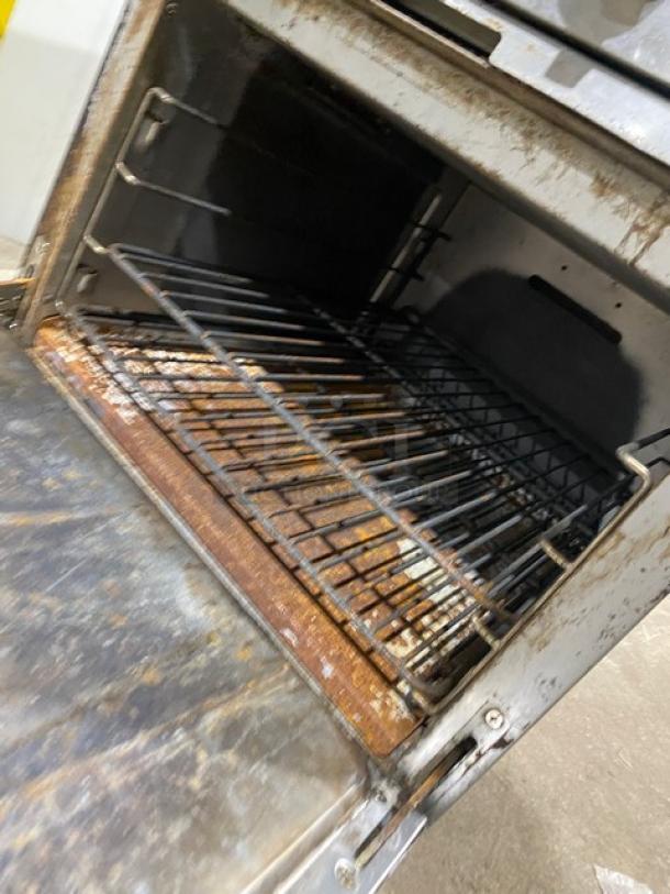 Patriot stainless steel natural gas 4-burner range/oven combo, model FMGR24NG, with rust and wear visible inside.