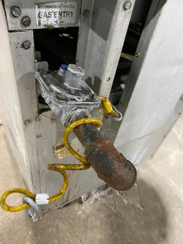 Patriot stainless steel gas range/oven, Model FMGR24NG, visible wear, with back splash, overhead salamander shelf, on casters.