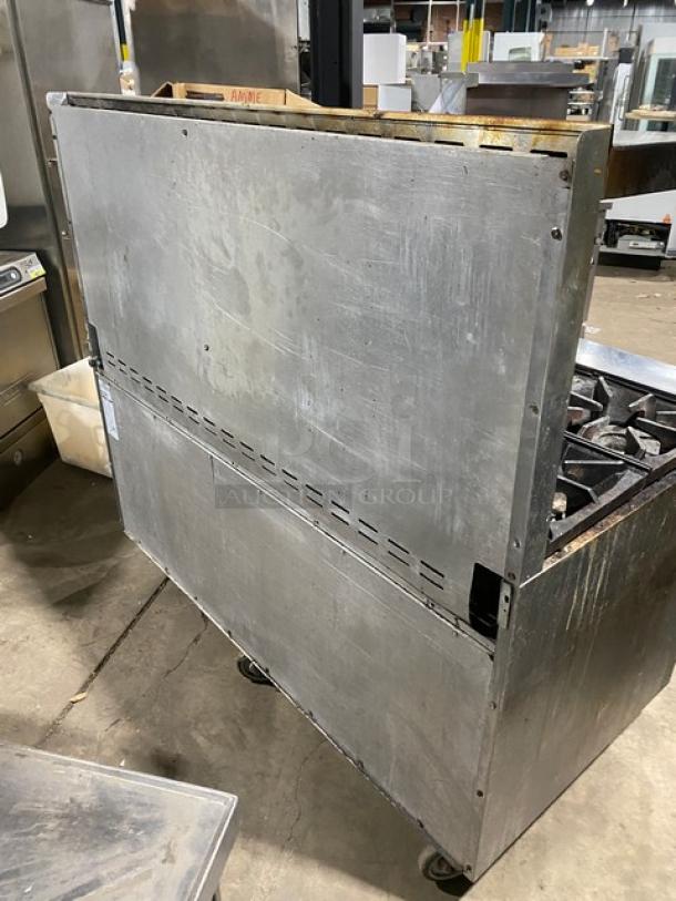 Bakers Pride commercial stainless steel 10-burner range with double oven, backsplash, salamander shelf, and casters.