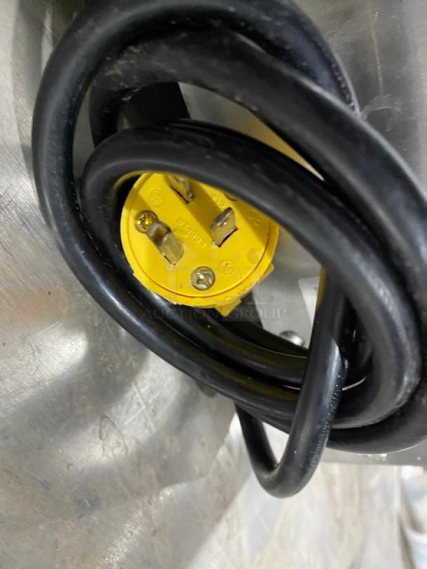 Coiled black power cord with a yellow plug on a stainless steel surface from a Star QCS Series Conveyor Toaster, Model QCS250C.