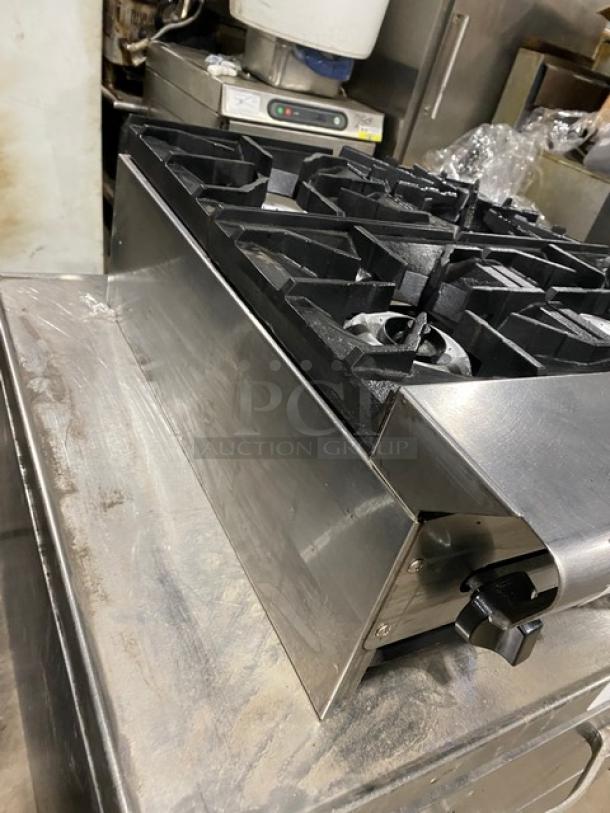 American Range commercial stainless steel gas-powered countertop 4-burner range in good condition, featuring heavy-duty cast iron grates.