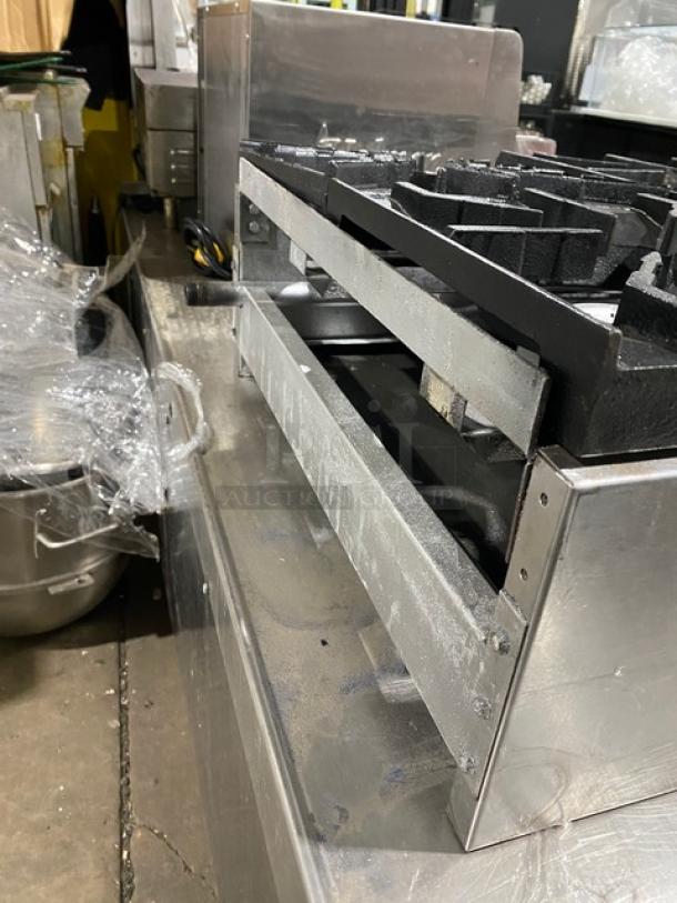 American Range stainless steel gas-powered countertop 4-burner range. Used condition, visible surface wear.