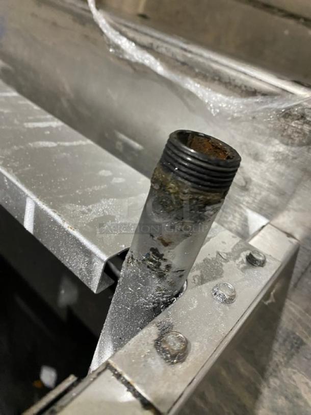 A damaged component of an American Range commercial stainless steel gas-powered countertop 4-burner range, showing corrosion.