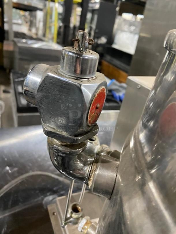 Groen commercial stainless steel electric tilting steam kettle, close-up of valve, shows signs of use, in good condition.