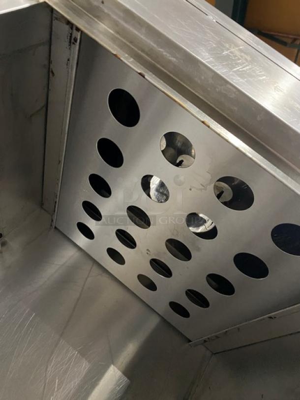 Commercial stainless steel gas-powered Chinese smoker oven, shown on legs. Features a perforated interior panel.