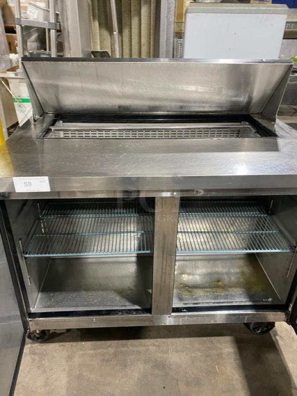 Dukers DSP48 stainless steel salad/sandwich prep table, bain marie style, with wired rack, on casters, 115V, used condition.