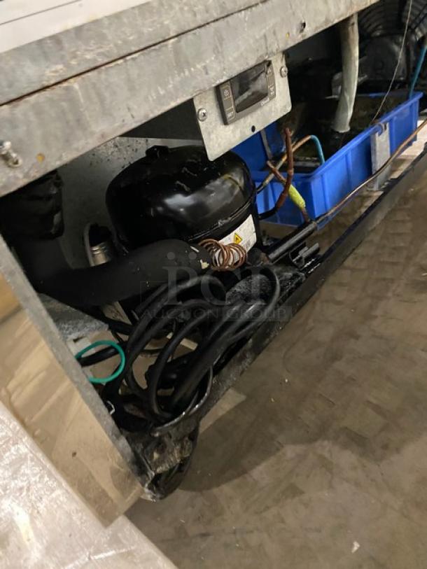 Dukers DSP48 stainless steel bain marie prep table, with wired rack, 115V, on casters. Model and serial number visible.