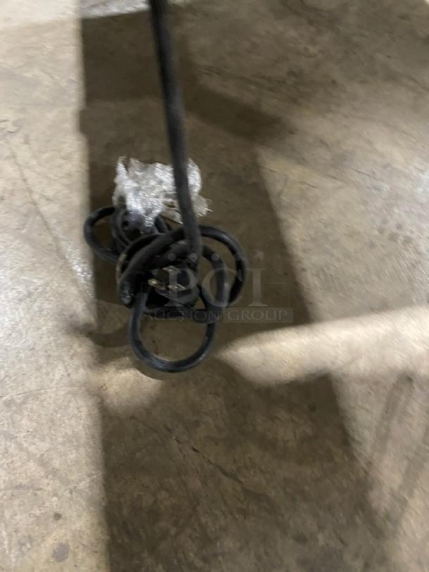 Cleveland Range stainless steel tilted braising pan on legs; commercial kitchen equipment; visible power cord; sturdy condition.