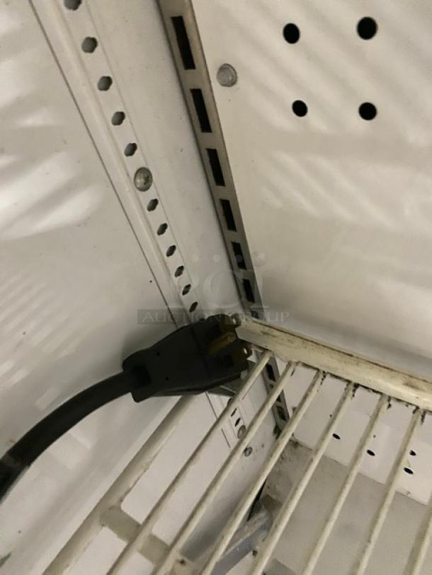 True TAC48LD refrigerated display case interior, showing adjustable poly-coated wire rack and power cord connection.