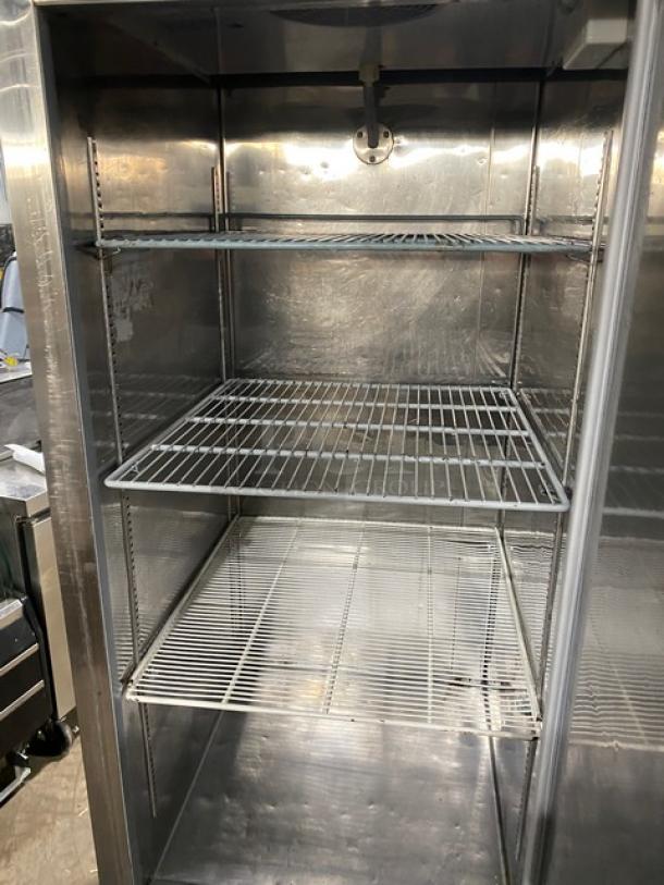 Universal commercial stainless steel reach-in freezer with poly-coated wire racks on casters. Clean interior.