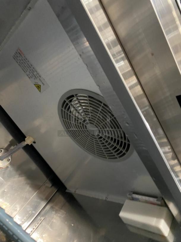 Universal stainless steel commercial reach-in freezer interior, showing fan and poly-coated wire rack, on casters.