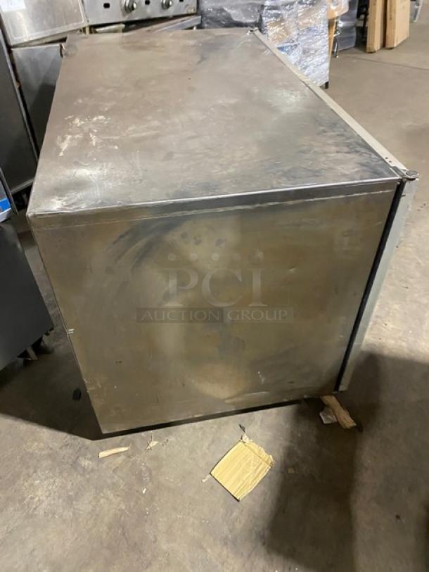 Silver King SKF48G commercial stainless steel undercounter freezer. Double glass doors, visible wear, 115V power.