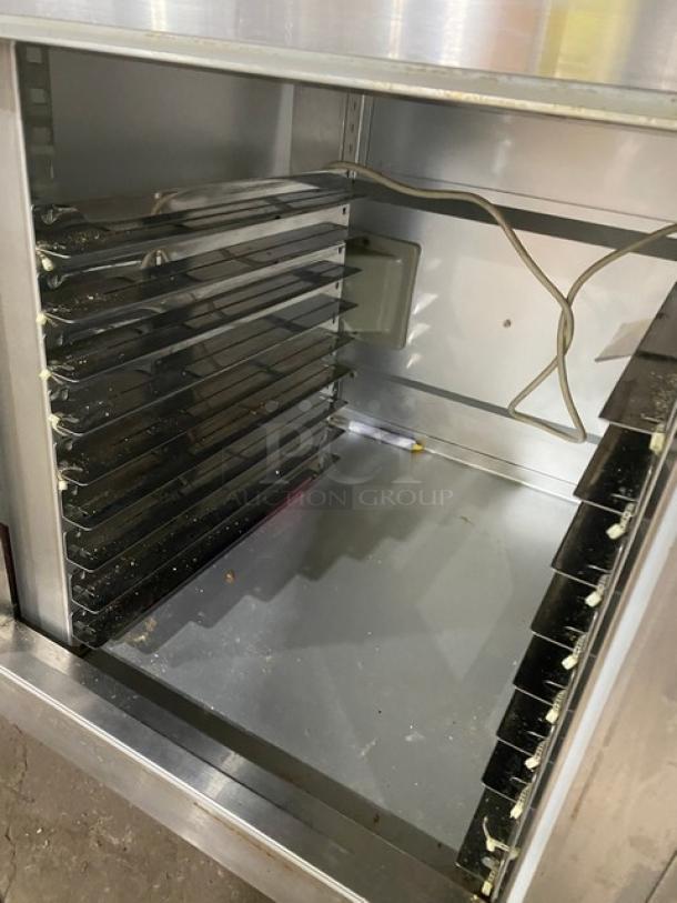 Traulsen stainless steel 2-door undercounter refrigerator, model UC2HT, with pan slide and chrome rack, on legs.