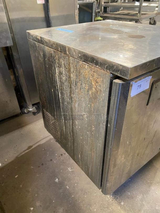 Delfield stainless steel undercounter refrigerator, model 406CA-DHL-DD1, with visible wear and on casters. Includes coated wire rack.