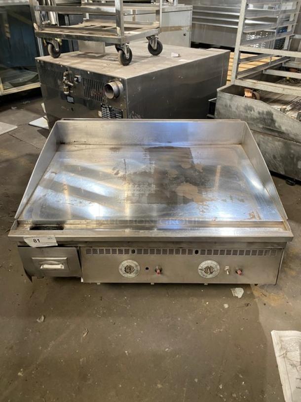 Keating commercial stainless steel gas countertop griddle, with back and side splash, thermostatic control, on legs.