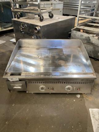 Keating commercial stainless steel gas countertop griddle, with back and side splash, thermostatic control, on legs.