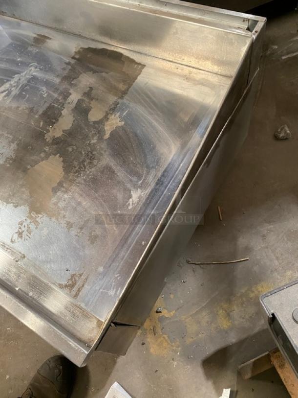 Keating commercial stainless steel gas-powered flat griddle with back and side splash, thermostatic control, on legs.