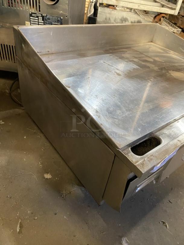 Keating stainless steel gas countertop flat griddle with back and side splash, thermostatic control, on legs, visible wear.