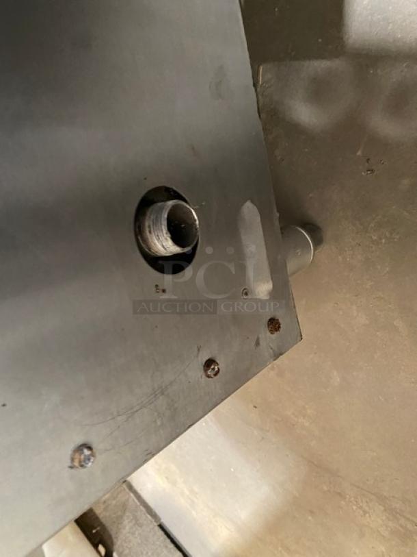 Keating stainless steel gas-powered countertop flat griddle with back and side splash, thermostatic control, on legs.