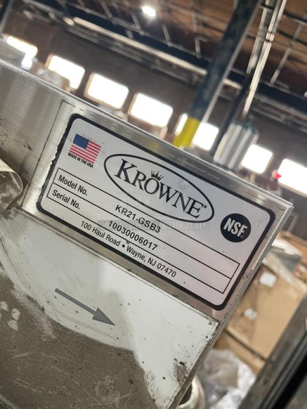 Krowne Royal 2100 Series stainless steel underbar glass storage unit, model KR21-GSB3, with drainboard and backsplash, on legs.