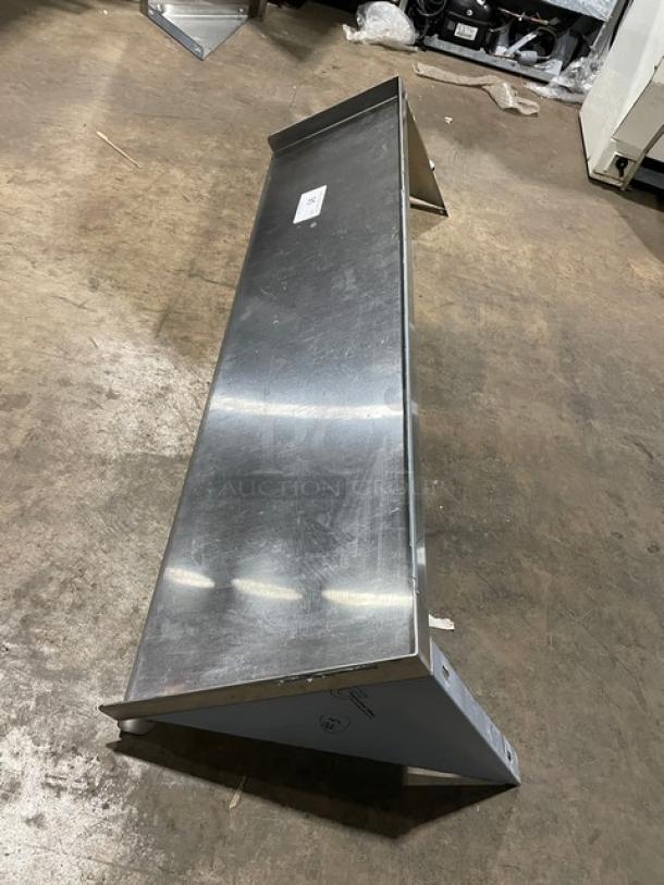 Commercial stainless steel rectangular wall-mount shelf, sturdy construction, lightly used condition, visible mounting brackets.