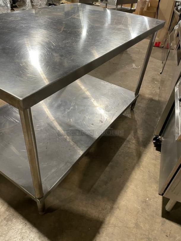 Commercial stainless steel worktop table with single undershelf, supported by sturdy legs. In good condition.