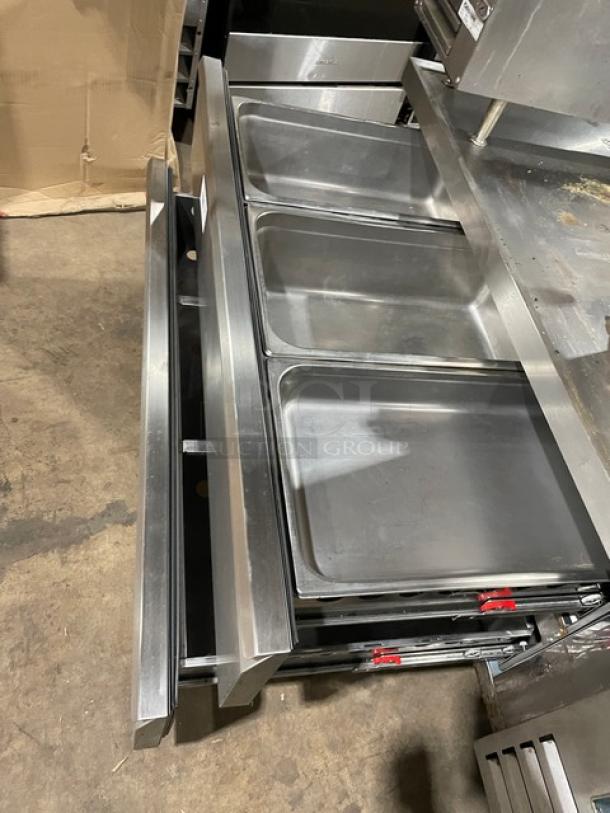 Arctic Air stainless steel 2-drawer refrigerated chef base, model ARCB60CZ, on casters, shown open with pans inside.