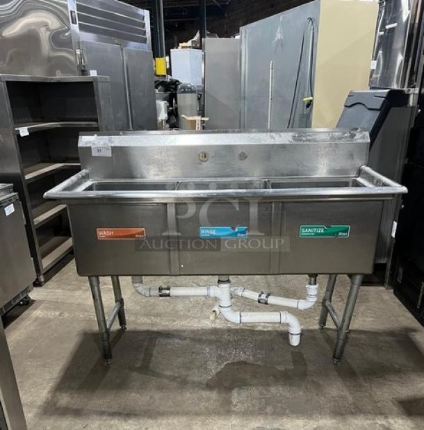 KCS commercial stainless steel 3-compartment dishwashing sink with backsplash, on legs, visible wash/rinse/sanitize labels.