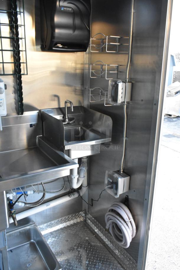 Interior of a new 2021 24' Cruising Kitchens Burger King trailer featuring stainless steel sink, shelving, and Sun Jamar dispenser.