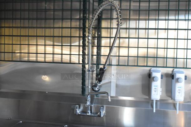 Stainless steel sink in Cruising Kitchens 24' Burger King trailer, featuring spring faucet and Ecolab dispensers.