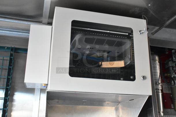 Mobile kitchen interior showing installed CaptiveAire grease hood and fire suppression system, part of a 2021 Cruising Kitchens 24' trailer.