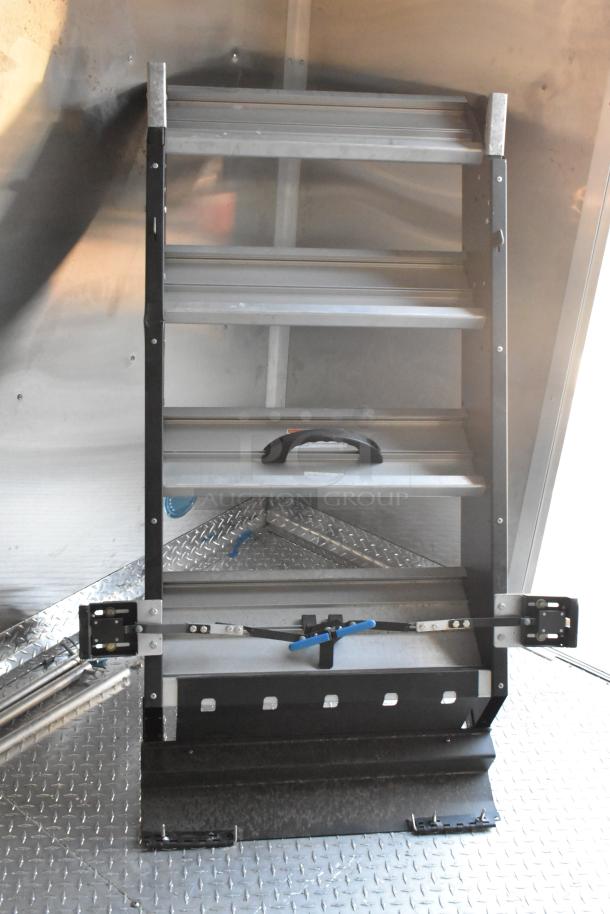 Interior view of a new 2021 24' Cruising Kitchens Burger King mobile kitchen trailer. Features foldable metal shelving.