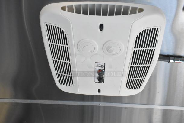 White overhead vent unit inside a Cruising Kitchens mobile kitchen trailer, featuring ventilation grilles and control knobs.