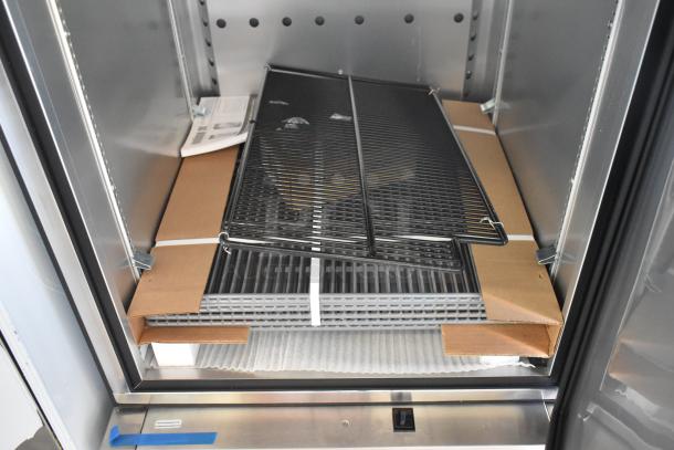 Brand new 2021 True T-23F-2-HC-MC freezer interior showing poly-coated racks, packaging, and manual, 115V, 1 phase.