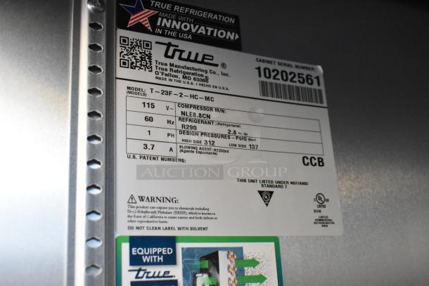 Alt text: Label detail of 2021 True T-23F-2-HC-MC freezer, showing model, voltage, refrigerant type, and safety warnings.