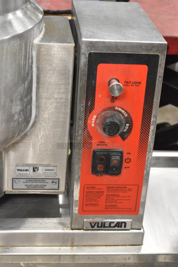 Vulcan K12ETT control panel with tilt lock, heat dial, on/off switch, and usage instructions on a stainless steel steam table station.