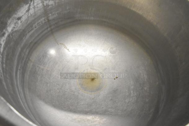 Interior view of a used Vulcan K12ETT 12-gallon tilting steam jacketed kettle, showing signs of wear with visible markings.