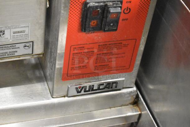 Vulcan steam table control panel with power switches, operational instructions, and brand label in commercial setting.
