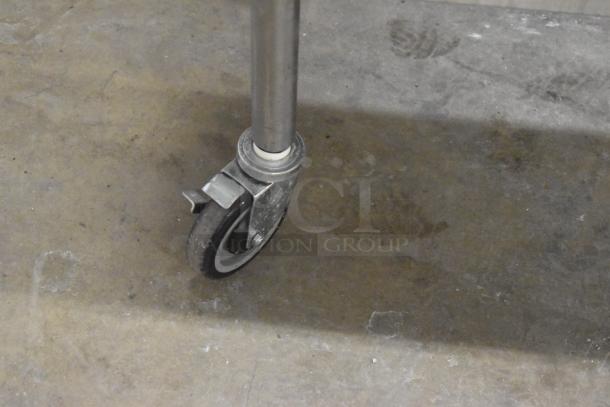 Commercial caster wheel for Vulcan steam table station, metal and rubber, attached to a stainless steel leg, in good condition.