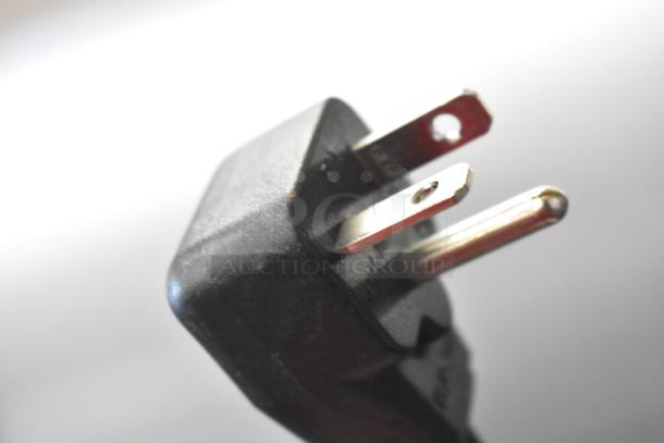 Close-up of a three-prong plug for the 2021 Menumaster OC24BK Commercial Countertop Microwave Oven, 208/240 Volts.
