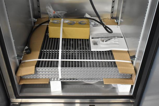 Brand new 2021 True T-23F-2-HC-MC freezer interior showing poly coated racks, packaging, and included accessories.