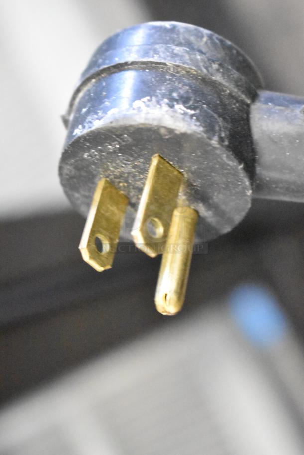 Close-up of a power plug for the Habco ESM12 commercial cooler merchandiser, showing prongs and slight surface wear.