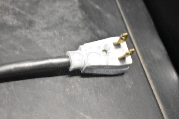 Close-up view of a 115-volt, 1-phase power plug for a True GDM-41SL-48-HC-LD cooler, showing the metal prongs.