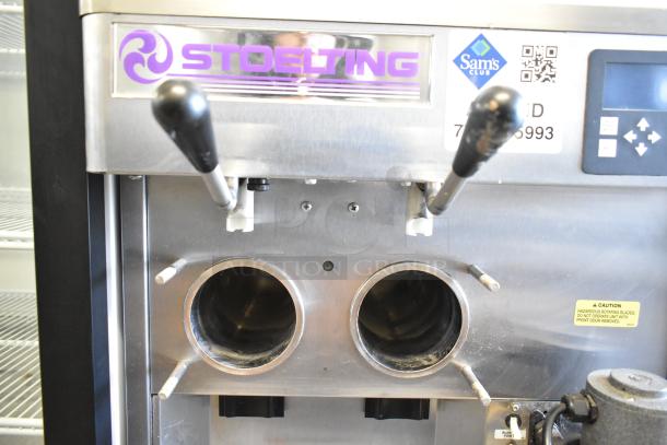Stoelting stainless steel commercial countertop soft serve ice cream machine with dual spouts and drink mixing attachment.