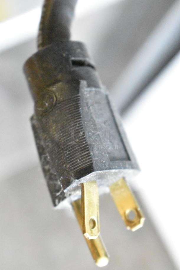 Close-up of a power plug for a Stoelting stainless steel countertop soft serve ice cream machine with a drink mixing attachment.