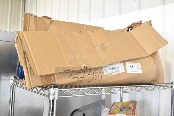 Four rolls of blue material in a damaged cardboard box on a metal shelf. Labels show item number FX39885 and quantity 4.