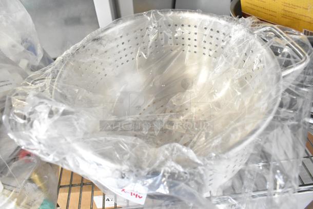 New Winco ALO-8BH colander wrapped in plastic, part of a scratch and dent auction lot, stainless steel construction.